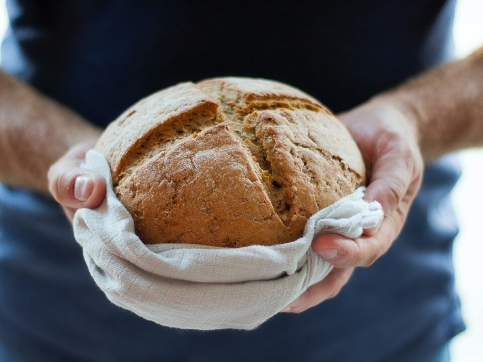 Hands holding loaf of bread