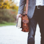 Stock image of man with bookbag and book