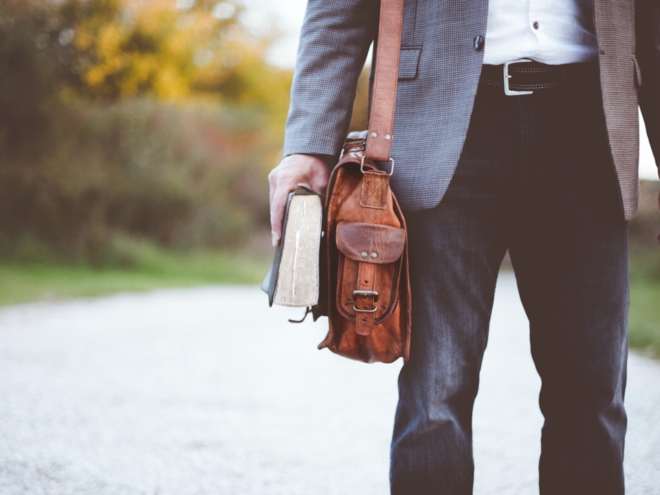 Stock image of man with bookbag and book